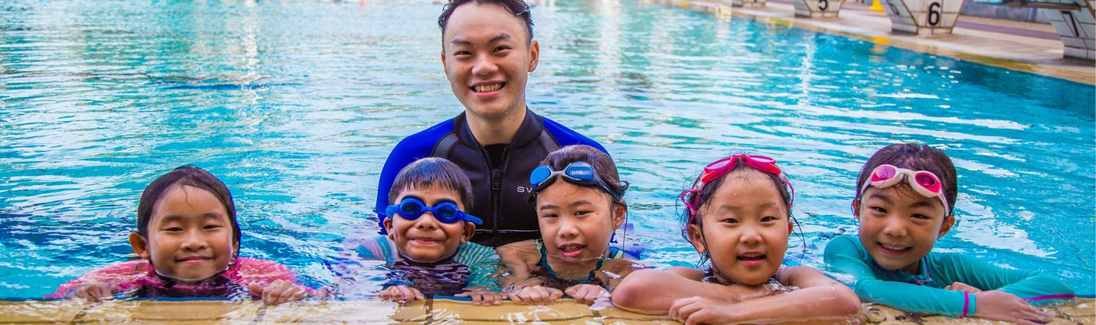 Happy Kids with a Coach from The Swim Lab After a Swimming Lesson