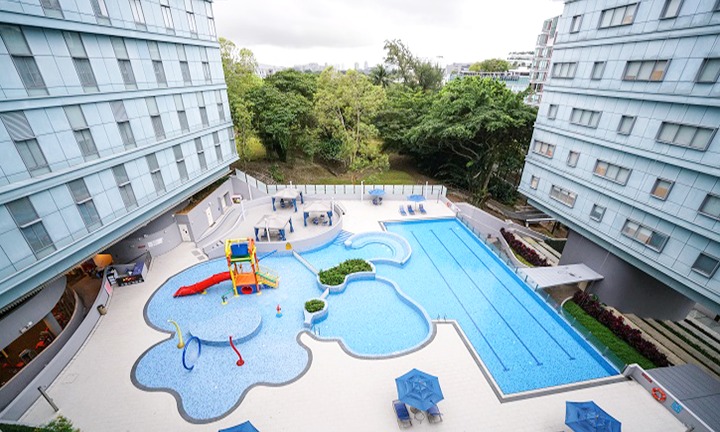 A panoramic view of the NTU@one-north swimming pool, featuring a 3 x 25m lap pool, adjacent learning pods, and surrounding lounge areas.
