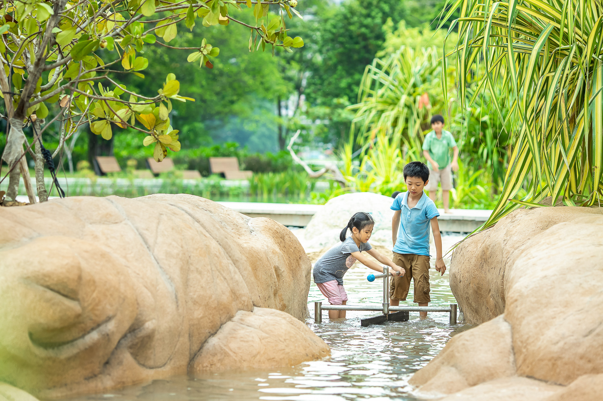 Young girl engrossed in operating a water mechanism, showcasing the blend of play and learning.