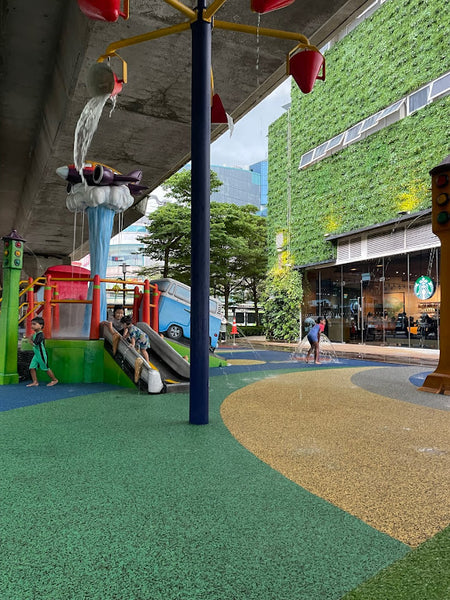 Children enjoying a multifaceted water playground featuring slides, a van, a train, and an airplane caught in a waterspout.